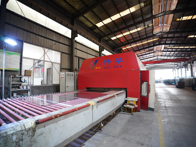 Tempered glass furnace operating in manufacturing workshop